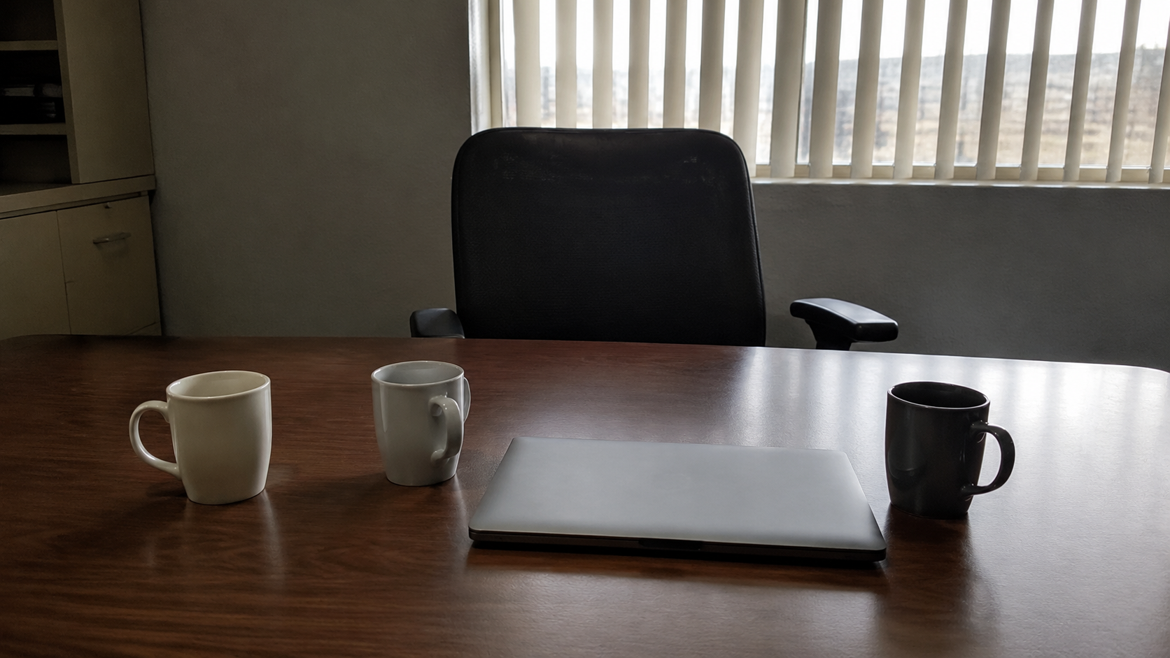 An empty chair at a conference table after a meeting in a contractor back office